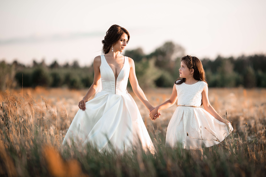 Happy woman in wedding dress with girl